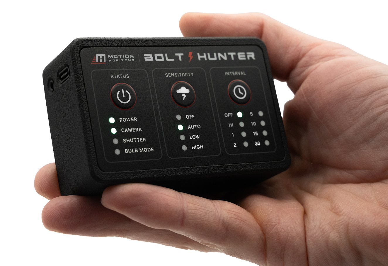 Close-up of a hand holding a black electronic device labeled 'Bolt Hunter' with various buttons and indicator lights.