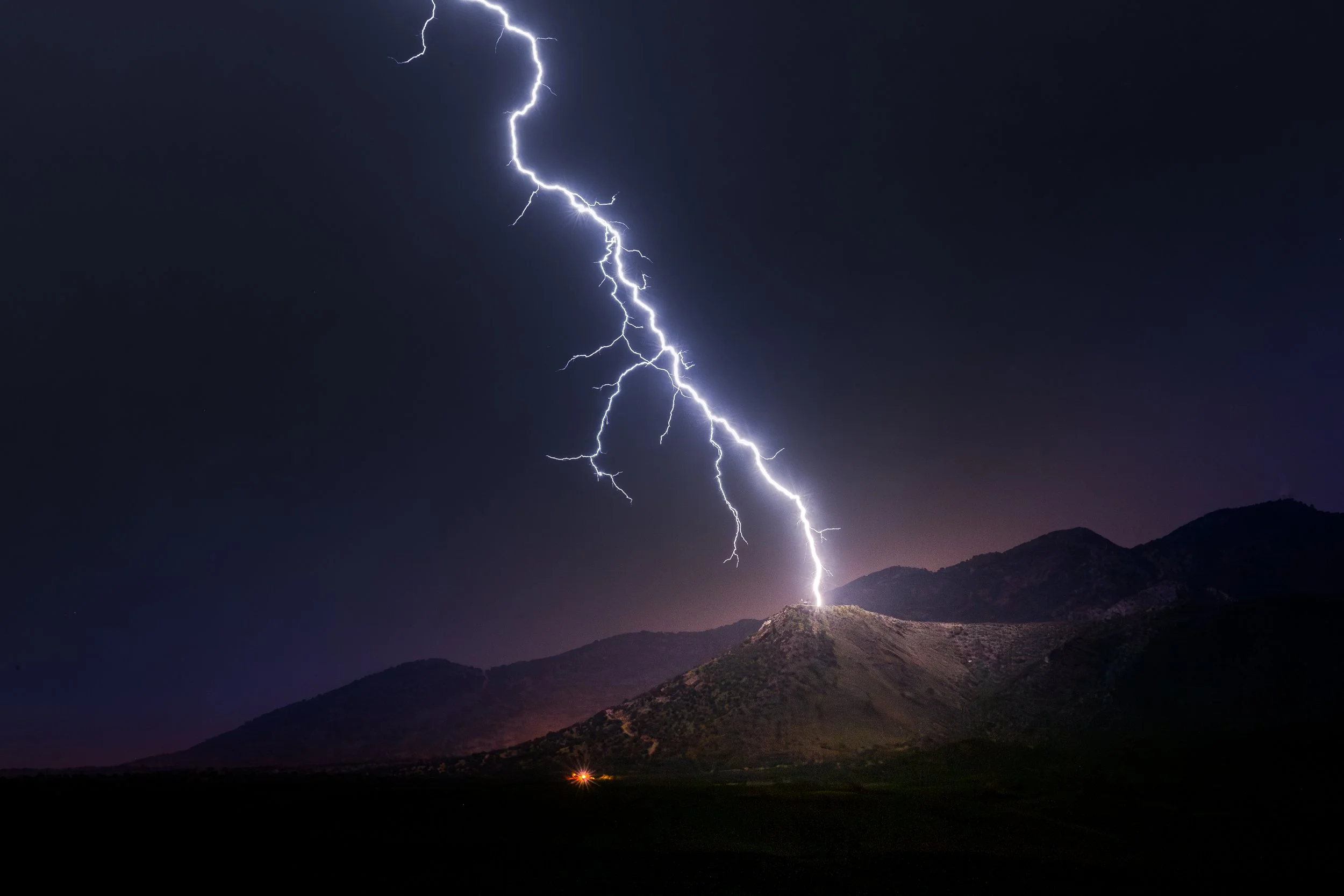 Lightning striking a mountain at night.