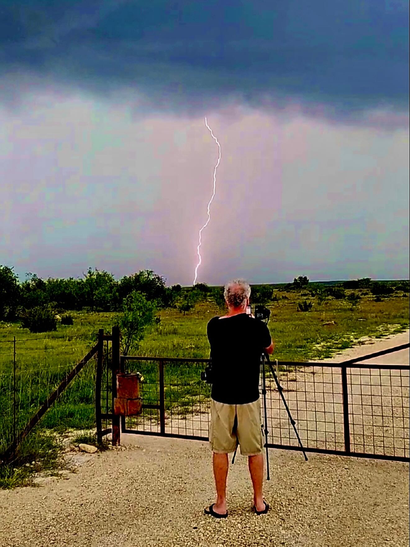 A photographer capturing lightning in the distance