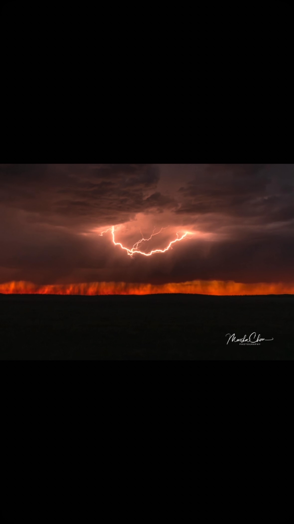 Lightning across a dark sunset sky