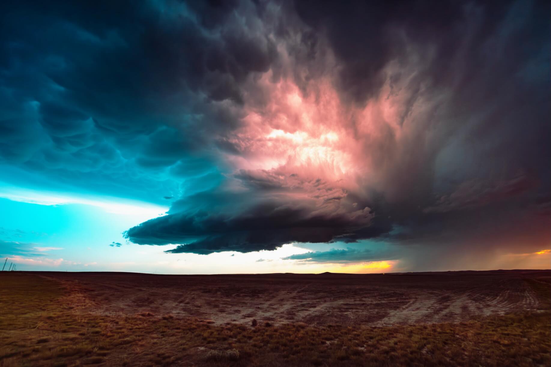Lightning illuminating a dramatic supercell at dusk