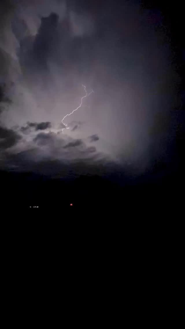 Lightning branching through nighttime storm clouds