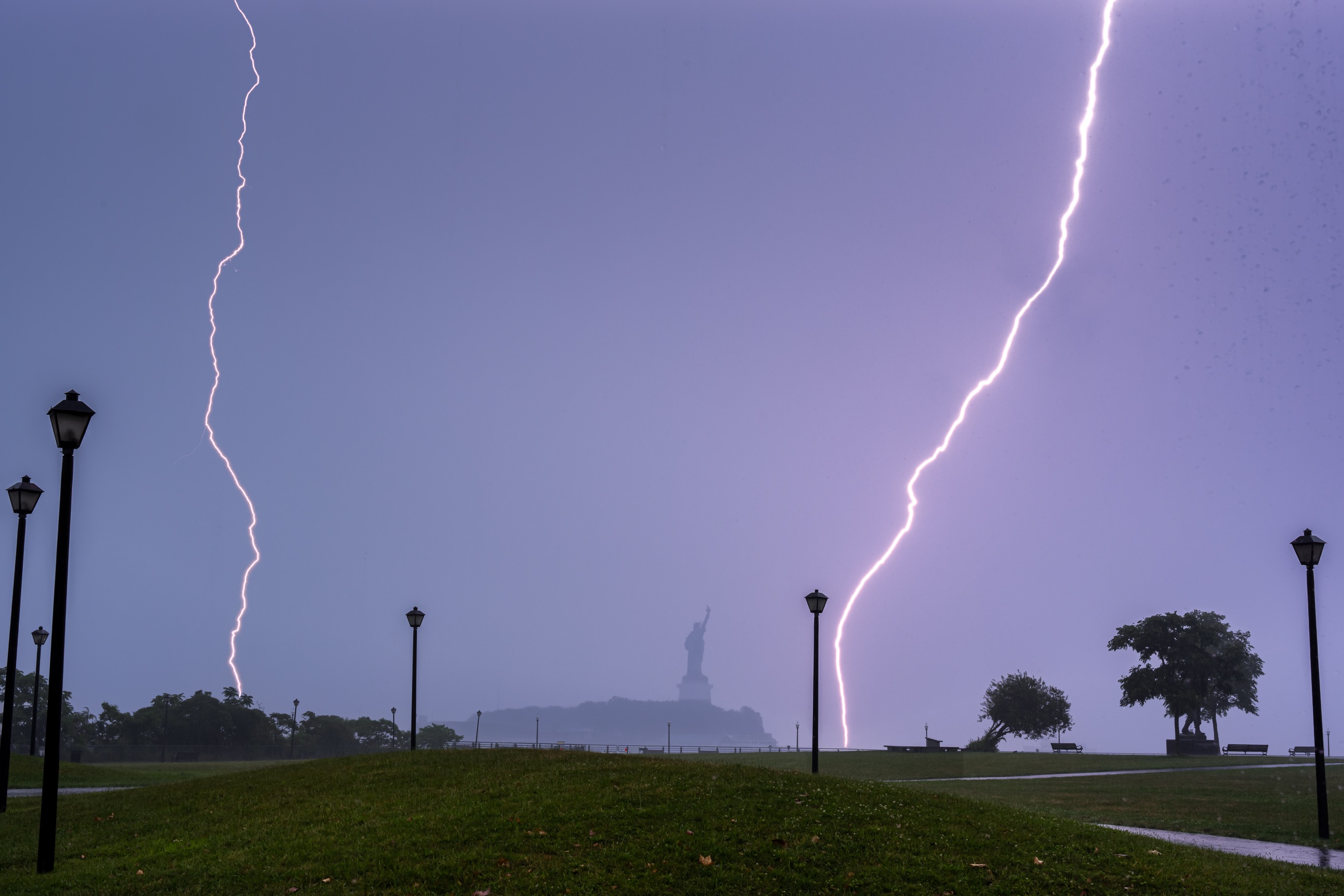 Twin lightning bolts behind the Statue of Liberty
