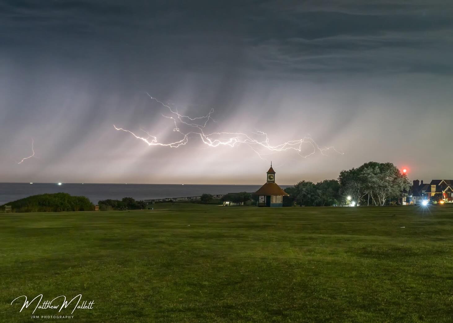 Lightning branching above a village and fields