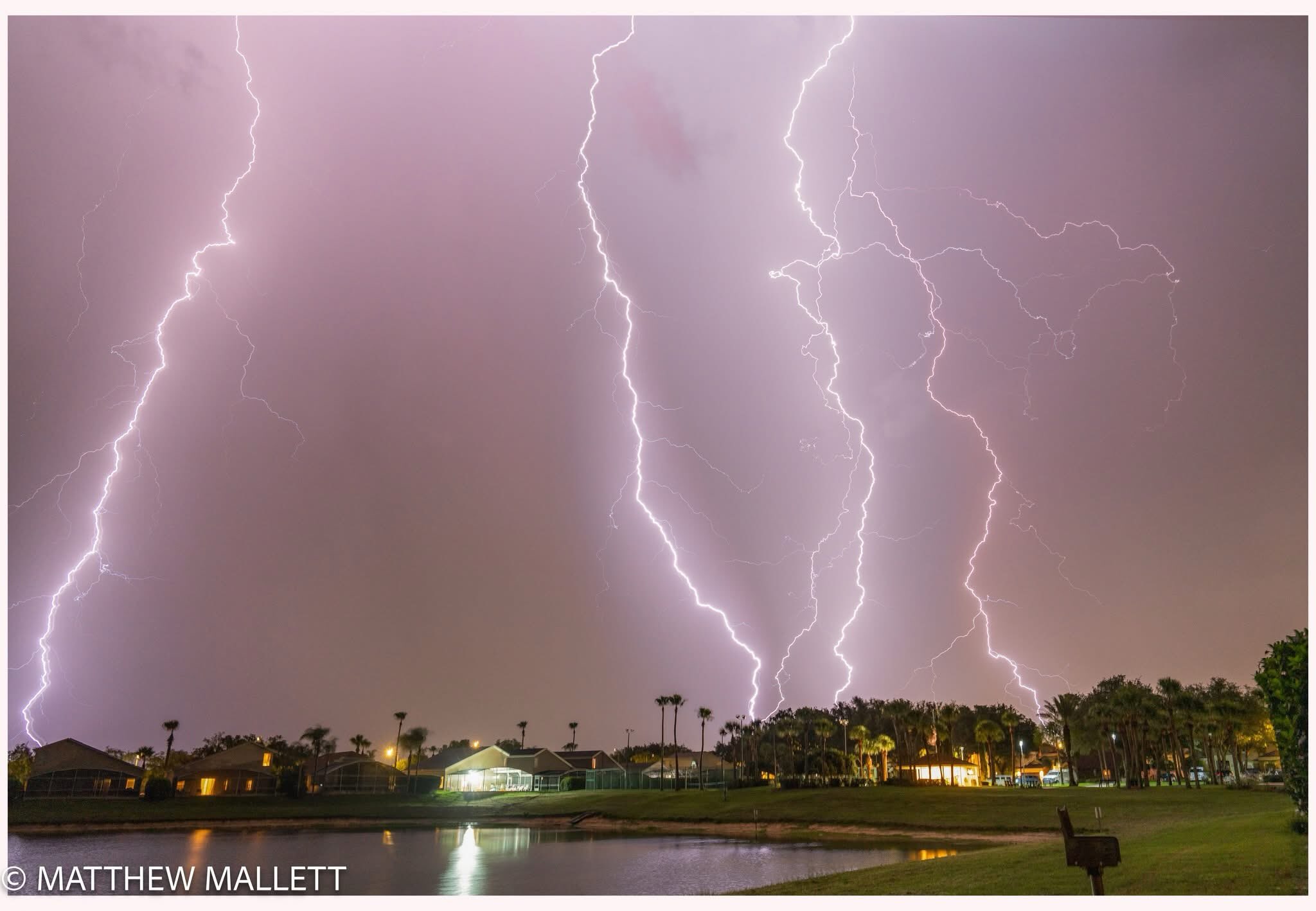 Multiple lightning bolts over a lake at night