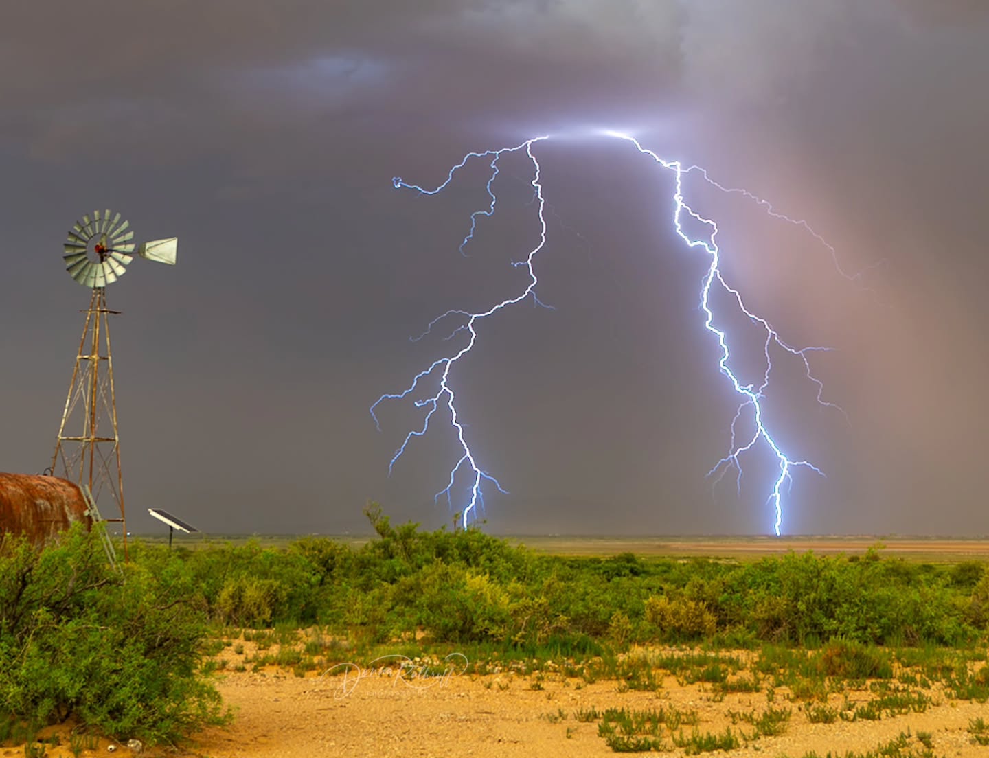 A bright lightning bolt beside a windmill