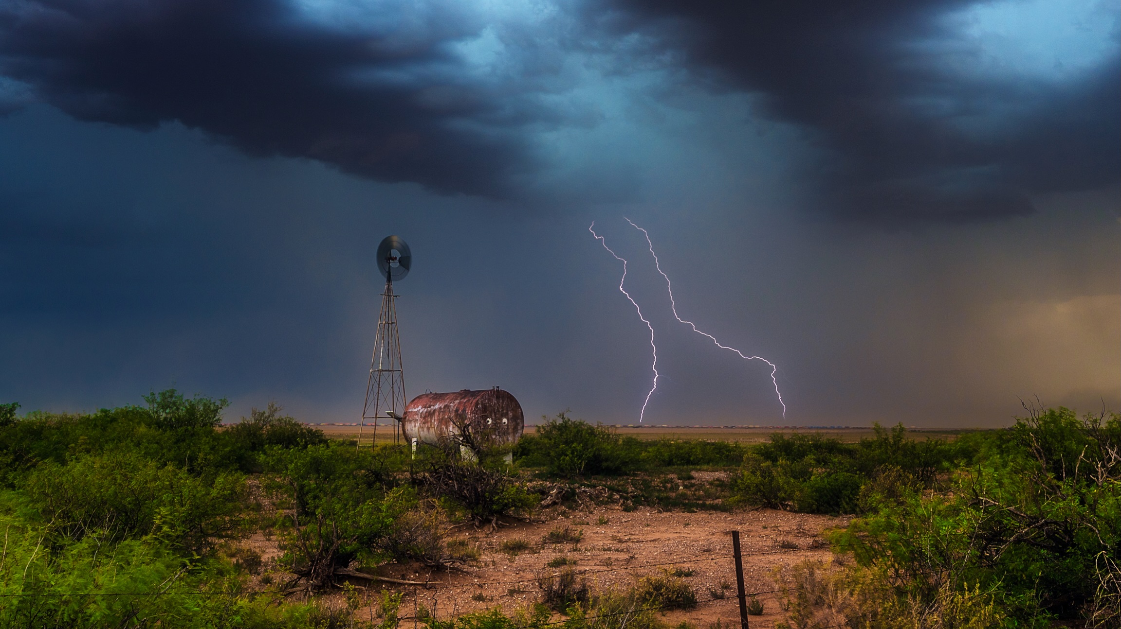 Lightning beyond a desert windmill