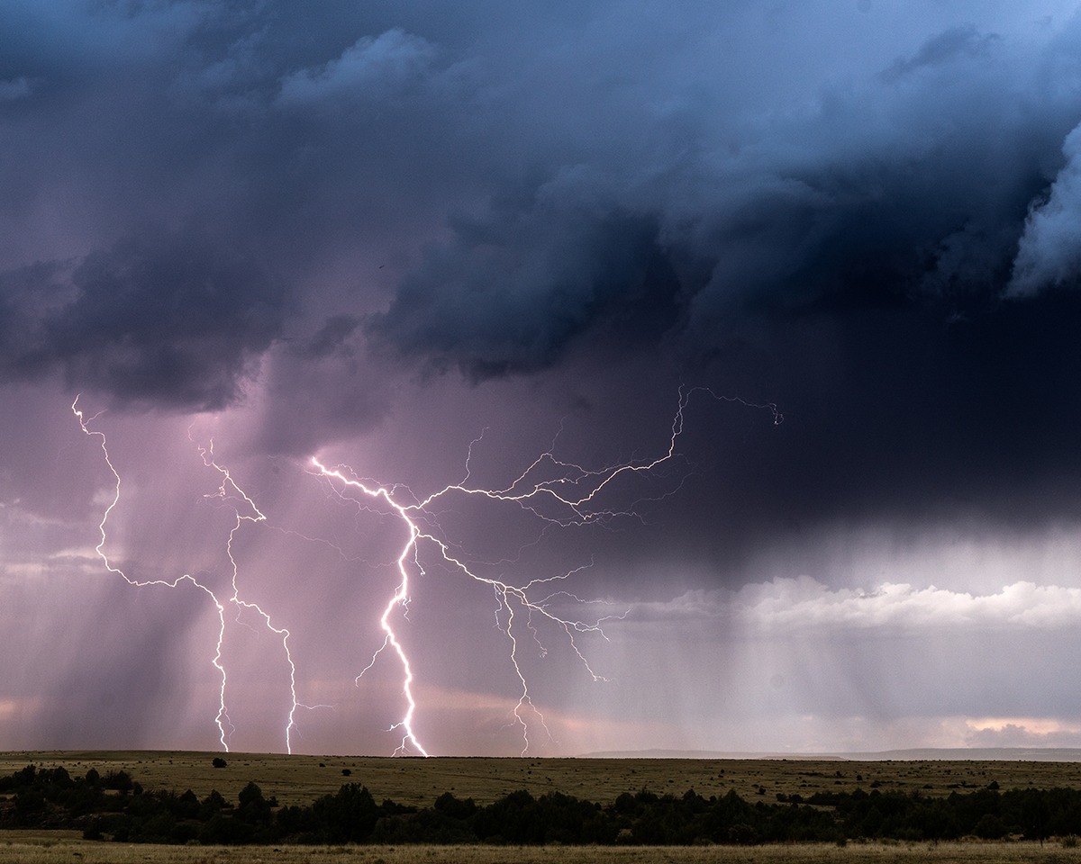 Lightning beneath dramatic thunderstorm clouds